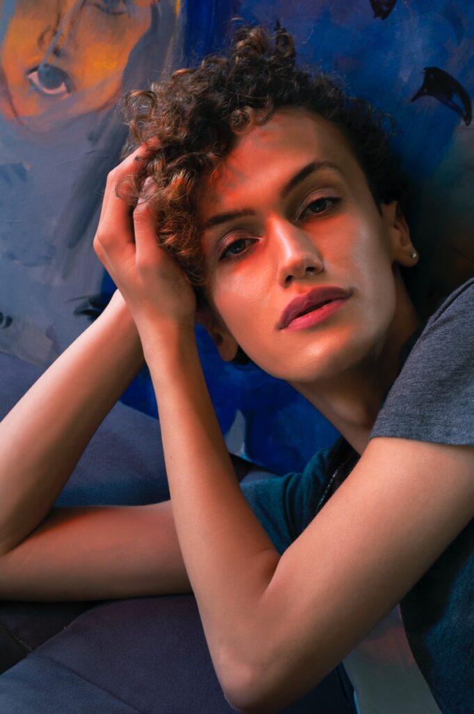woman in gray shirt lying on blue textile