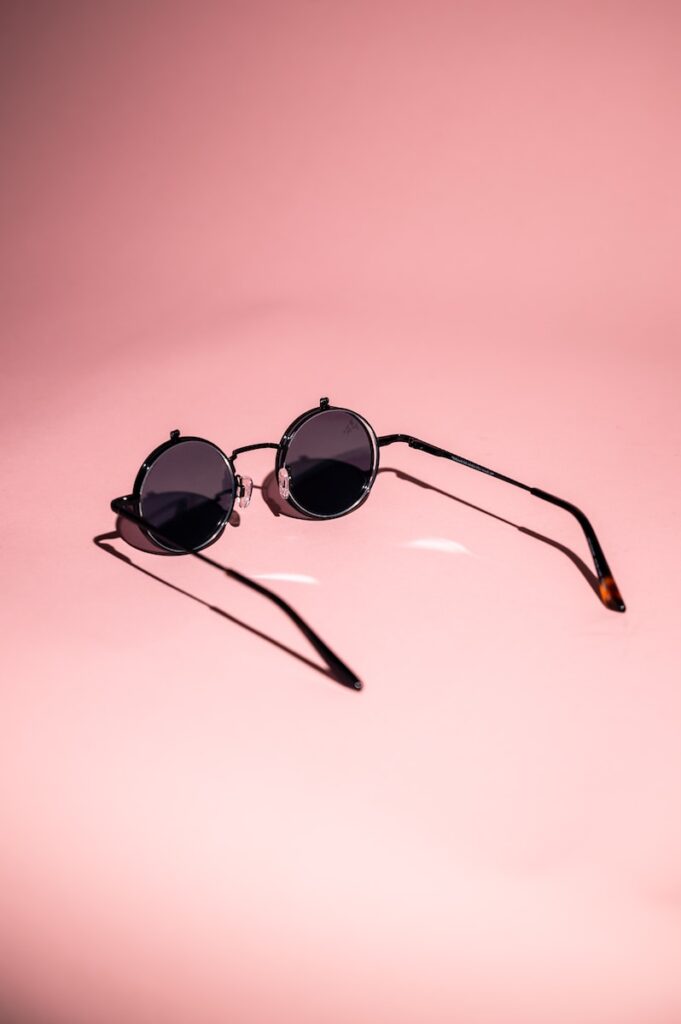 black framed sunglasses on white surface, Feminization