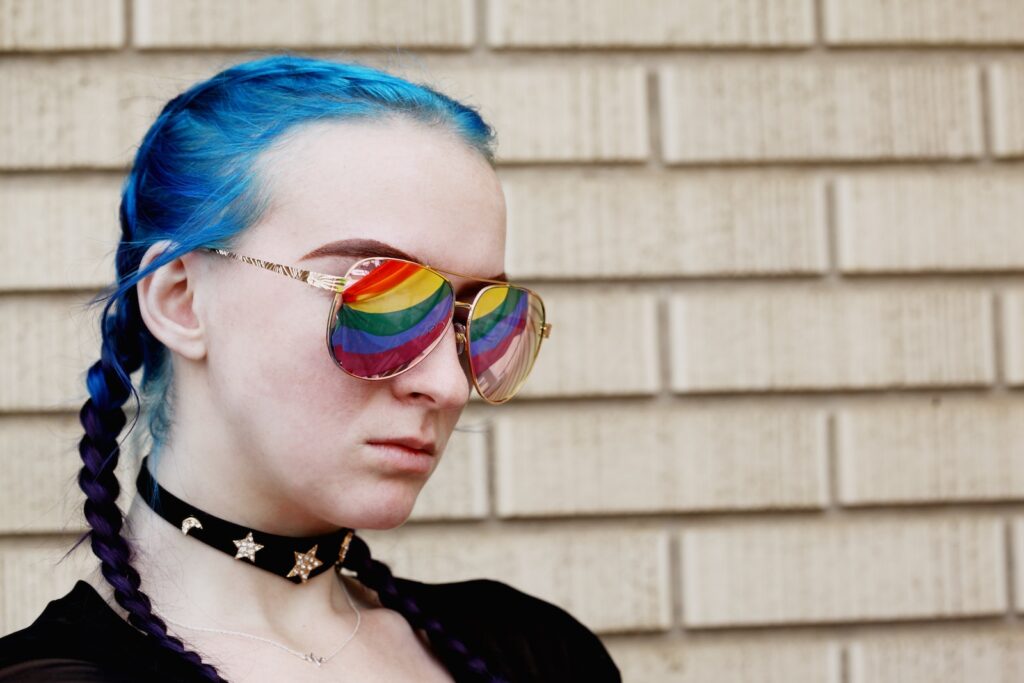 a woman with blue hair and rainbow glasses, Male to Female Transformation