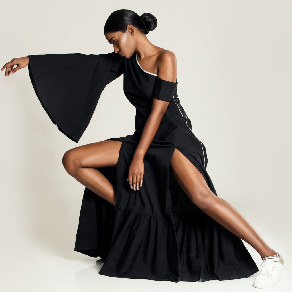 woman in black one shoulder dress posing