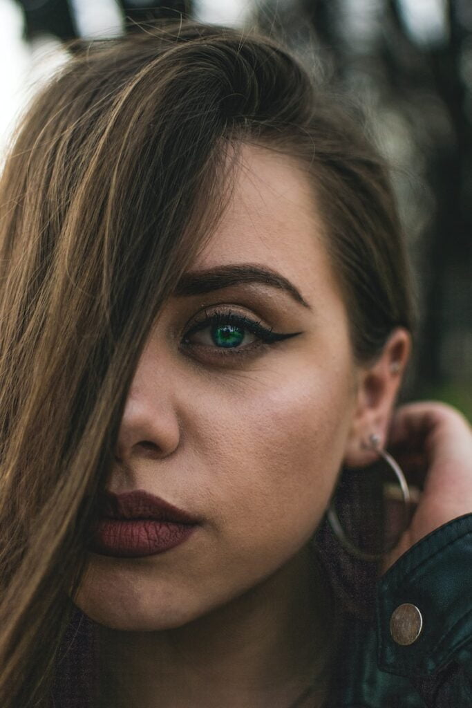 Fox Eye versus Cat Eye: welke trendy look voor chirurgie past bij u? vrouw met haar aan de achterkant van haar oor en neemt selfie