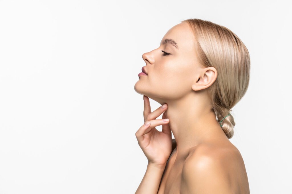 Kaakverkleining en recontouring bij gezichtsfeminisatiechirurgie mooi jong meisje wat betreft haar gezicht jeugd huidverzorging concept