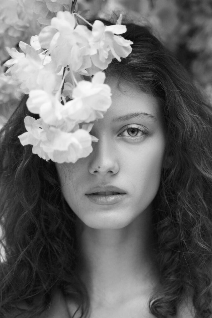 woman posing with flowers black white front view