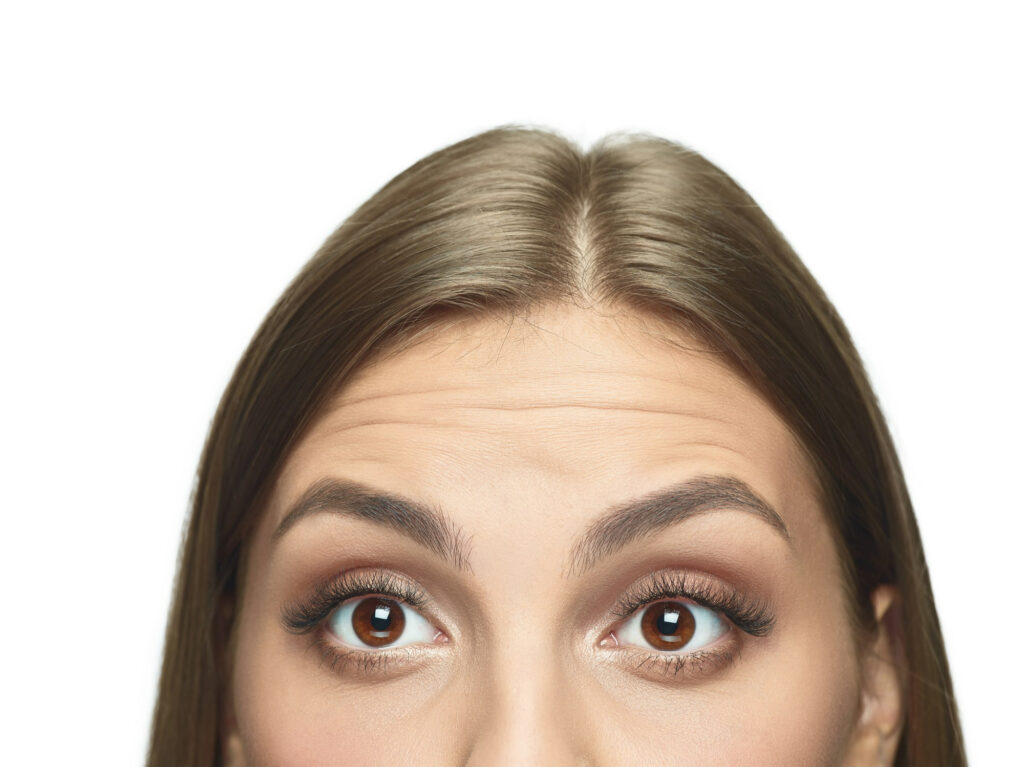 De betekenis van haarlijnverlaging bij gezichtsfeminisering close-up portret jonge vrouw ogen zonder rimpels
