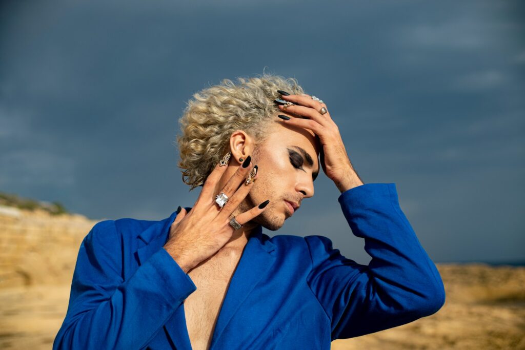 Eye Makeup for Men: 3 Powerful Hacks for a Confident Look 4 a man in a blue shirt holding his hands to his head